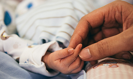 Die Hand einer Frau hält die Hand eines Babys