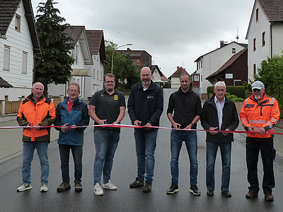 Die Herren schneiden ein Band durch.