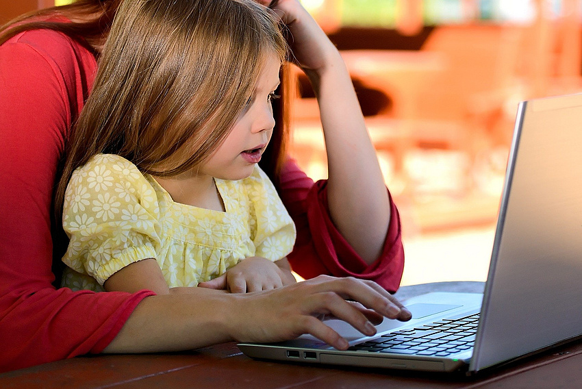 Frau und Mädchen vor Laptop