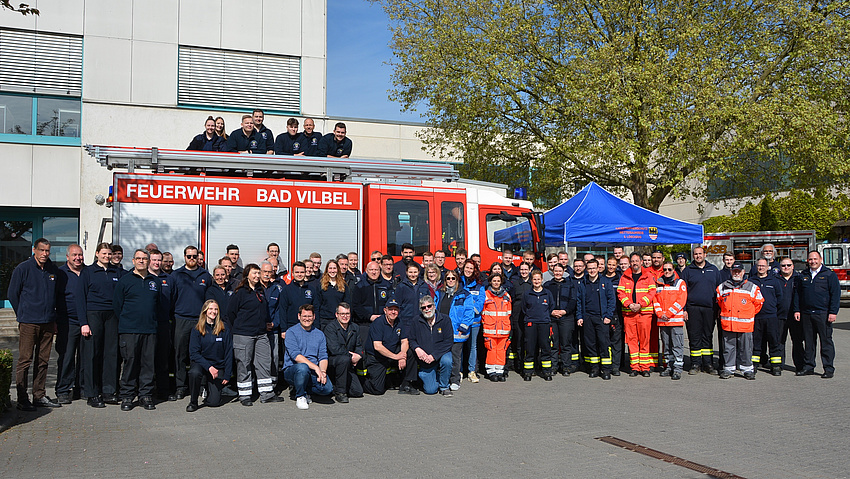 Viele Menschen stehen vor einem Feuerwehrauto.