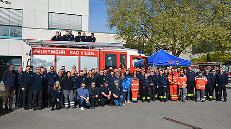 Viele Menschen stehen vor einem Feuerwehrauto.