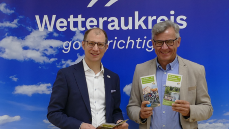 Landrat Jan Weckler und Volker Spies (Geschäftsführer der TourismusRegion Wetterau) präsentieren die Neuauflagen der Broschüren.
