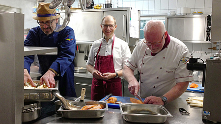 Drei Männer kochen in der Küche eines Restaurants
